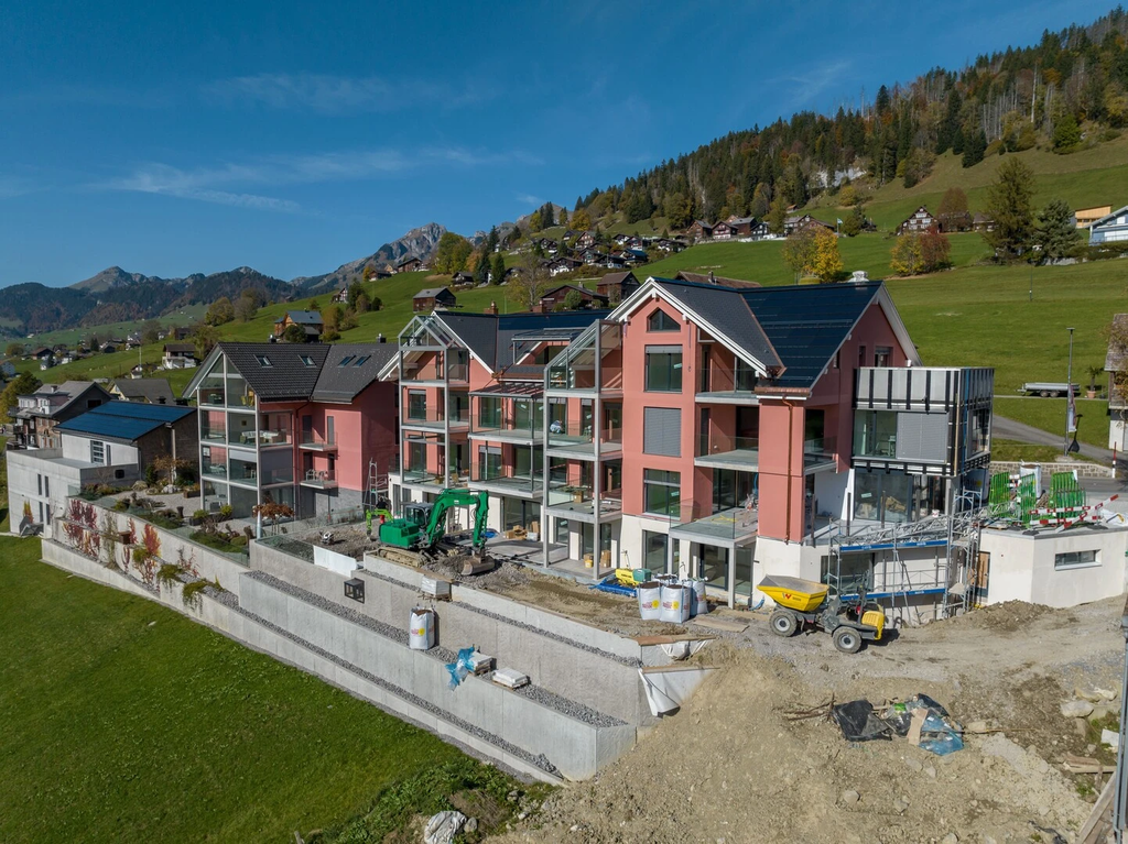 Wohngebäude mit Balkonen und moderner Fassadenlösung in alpiner Umgebung